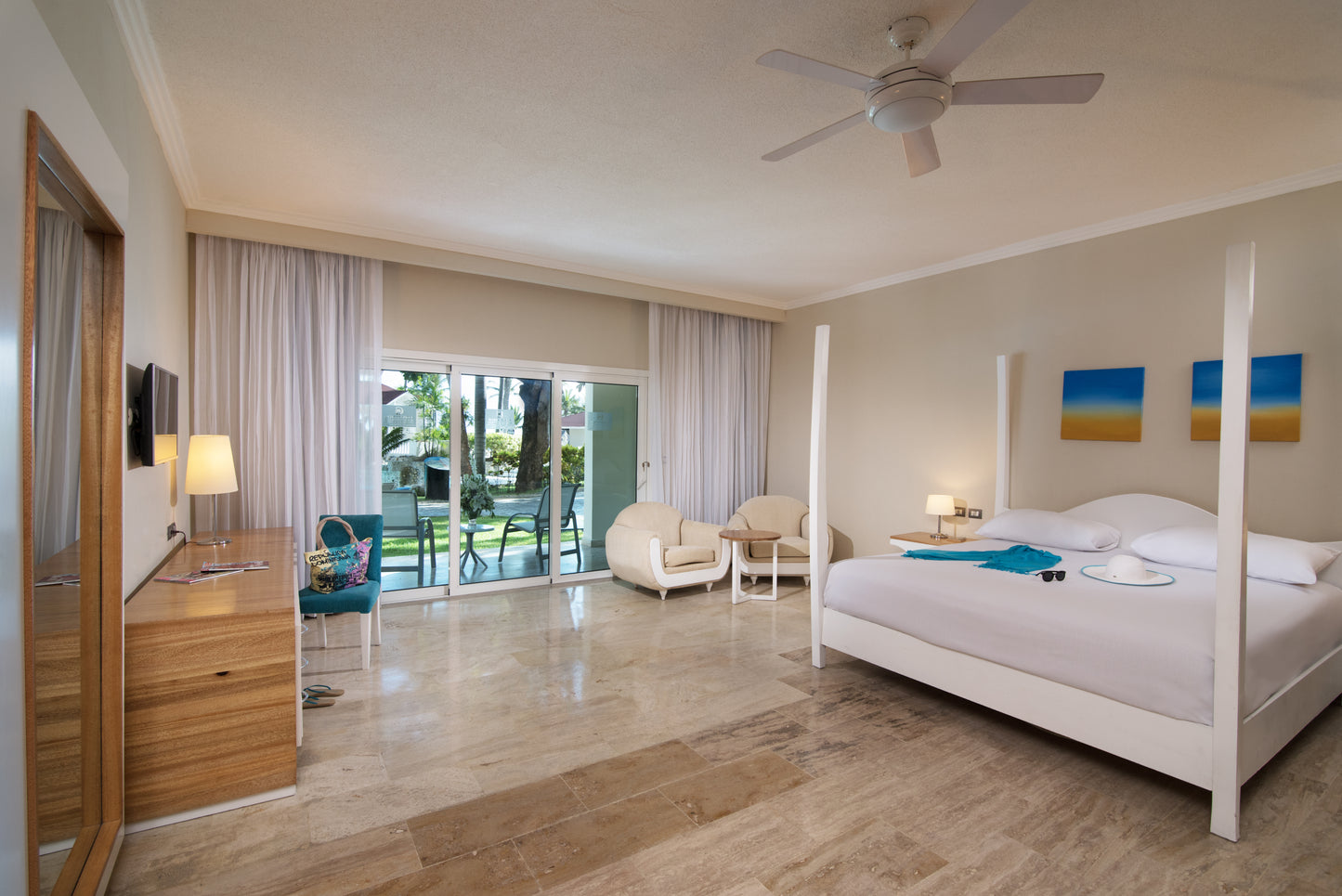 Well-appointed guest room at Confresi Palms Puerta Plata Resort with modern decor and a balcony with resort view.